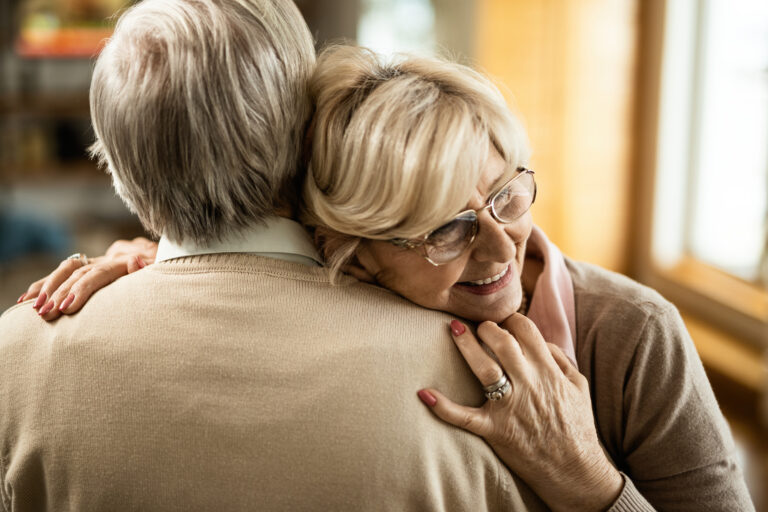 happy senior couple embracing at home.